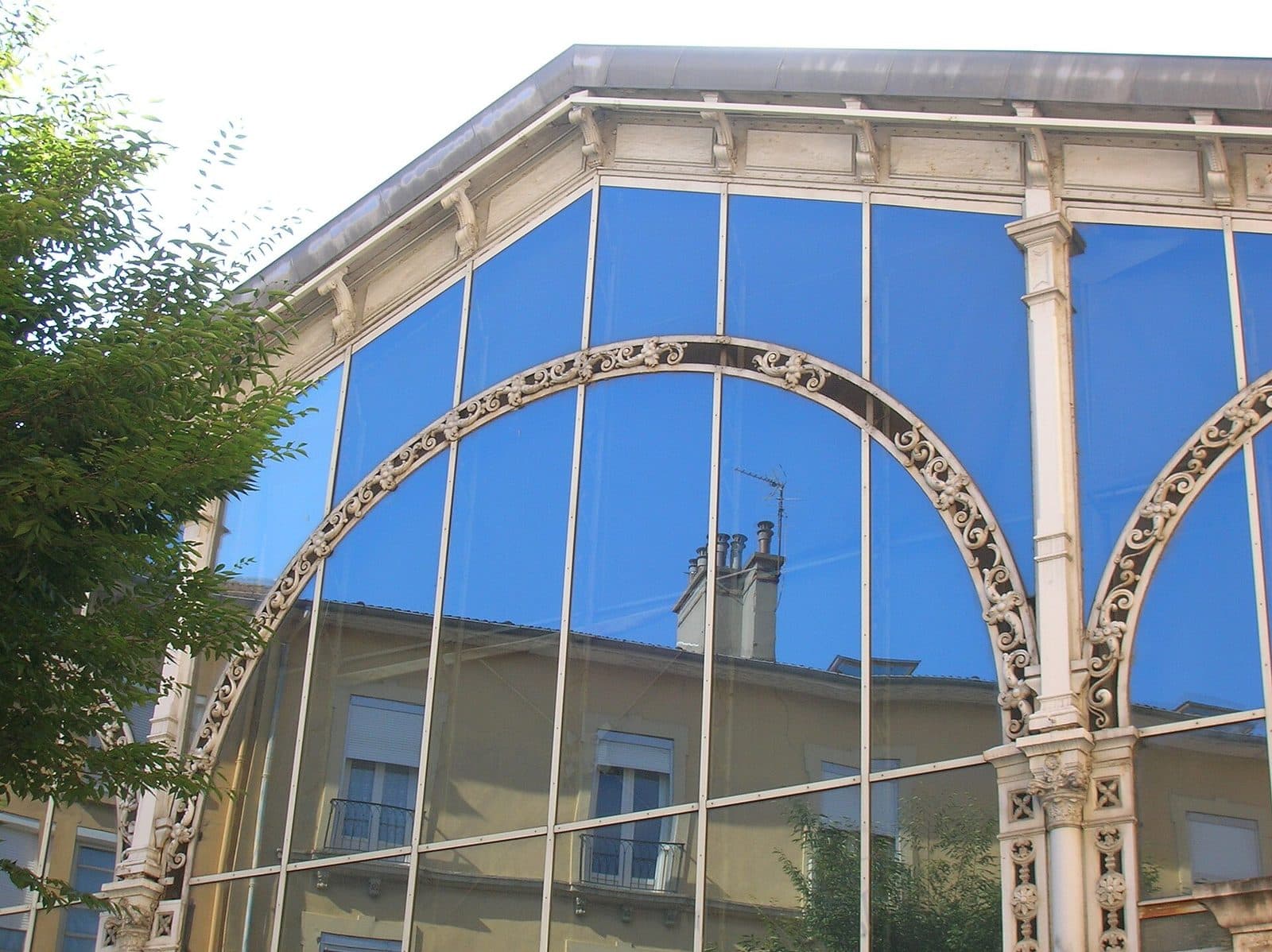 Détail des arcs de fonte de la halle et de leur remplissage ajouré, se découpant sur le ciel.