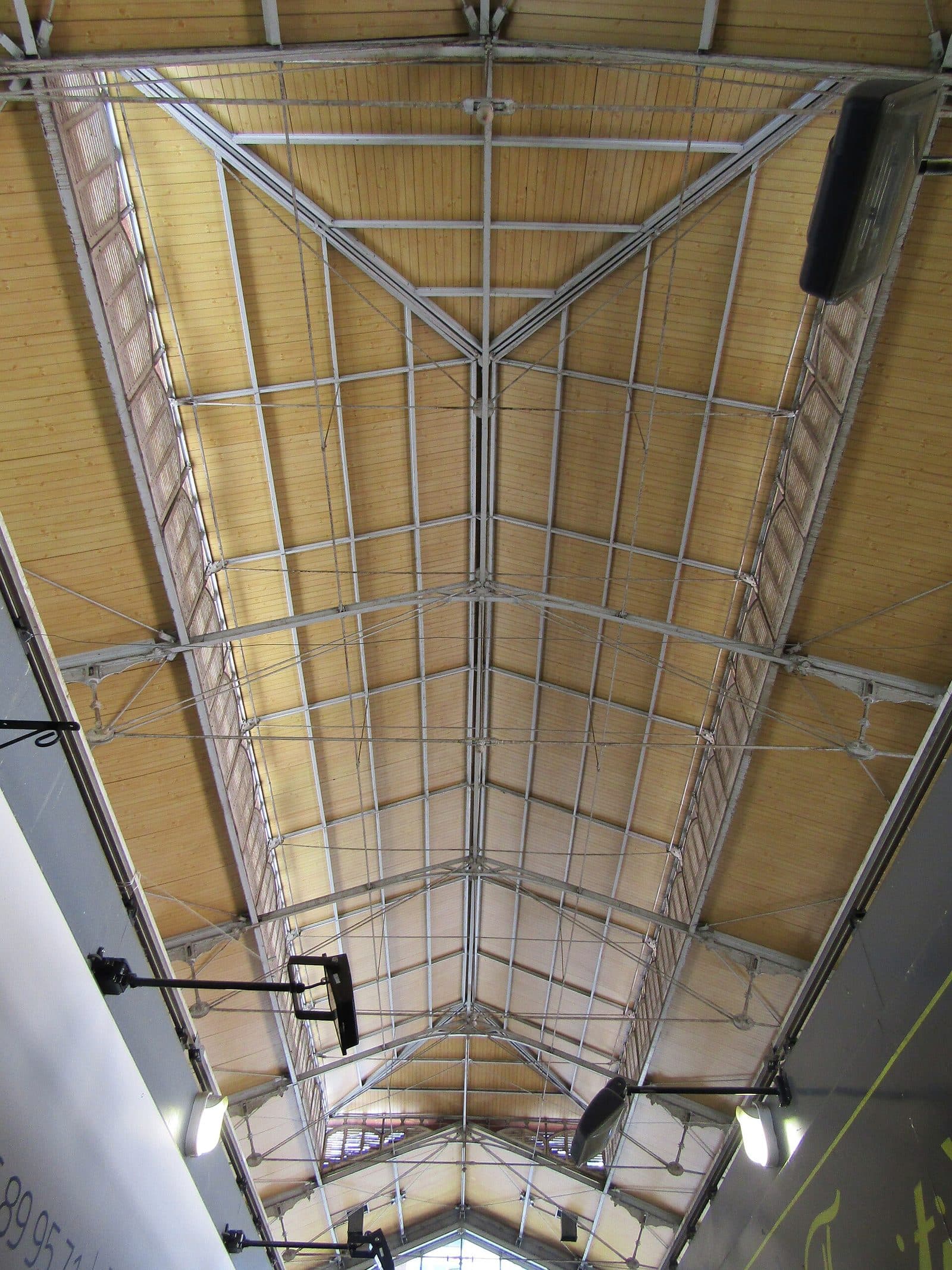Le lanterneau de la halle vu de dessous : la charpente métallique et les persiennes de bois qui ventilent le bâtiment.