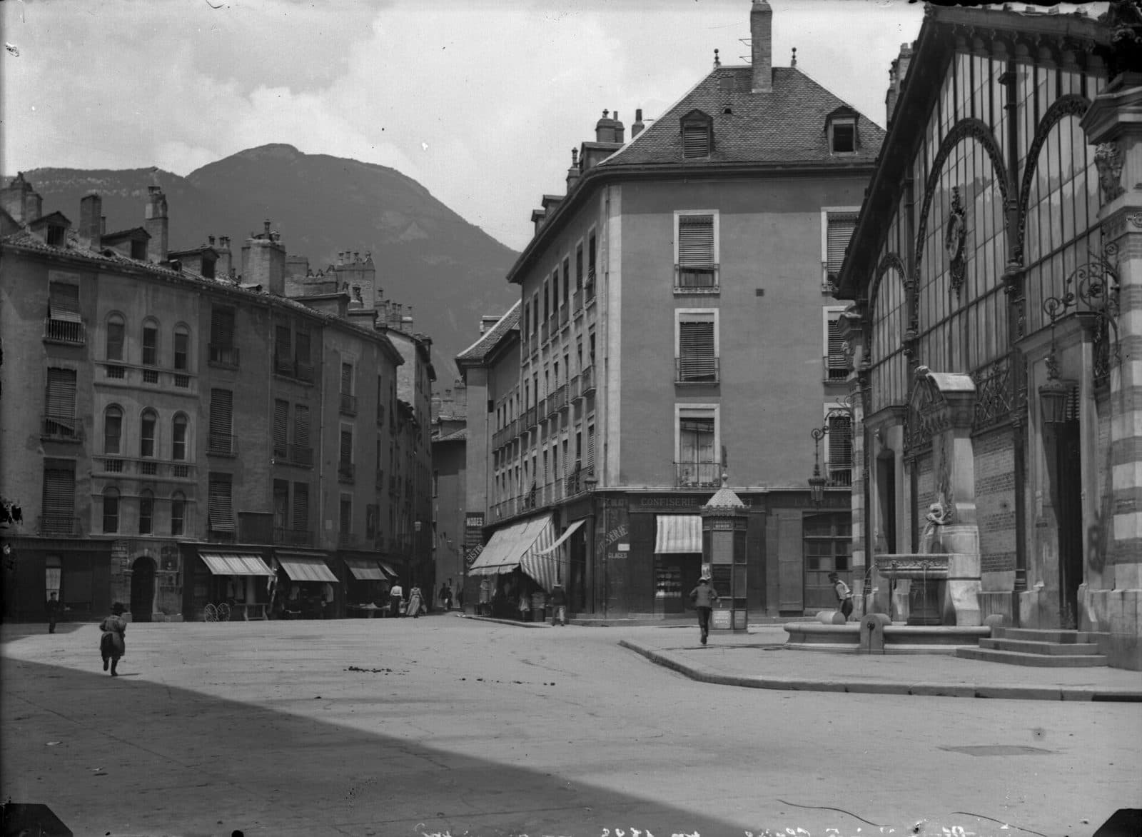 La place Sainte-Claire et la halle au début du XXᵉ siècle, les montagnes fermant la perspective.