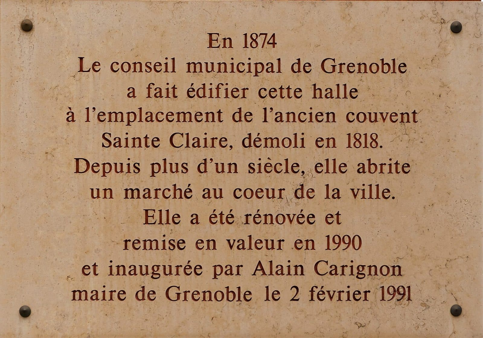 Plaque commémorative apposée sur la halle, rappelant sa construction en 1874 et sa rénovation en 1990.